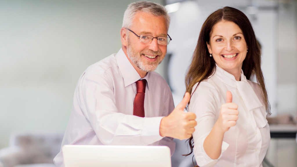 portrait-smiling-senior-employees-showing-thumb-up-sign-office